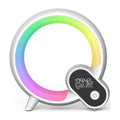 A modern circular smart home device with a white frame and a colorful RGB light ring, featuring a small digital display on the front showing the time and temperature, set against a plain white background.