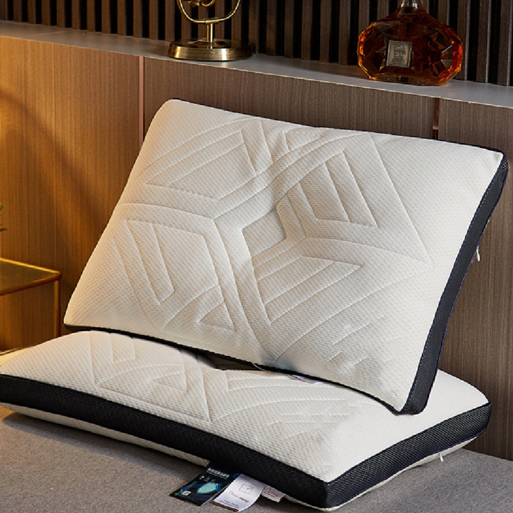 Two white quilted memory foam pillows stacked on a gray surface, with a dark navy border. The top pillow is propped up against a wooden wall background, and a product tag is visible at the bottom.