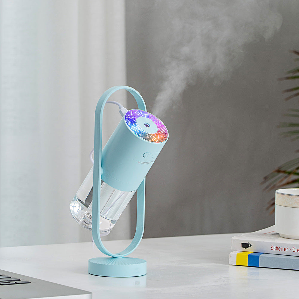 Teal USB shadow projection humidifier with color-changing light on desk